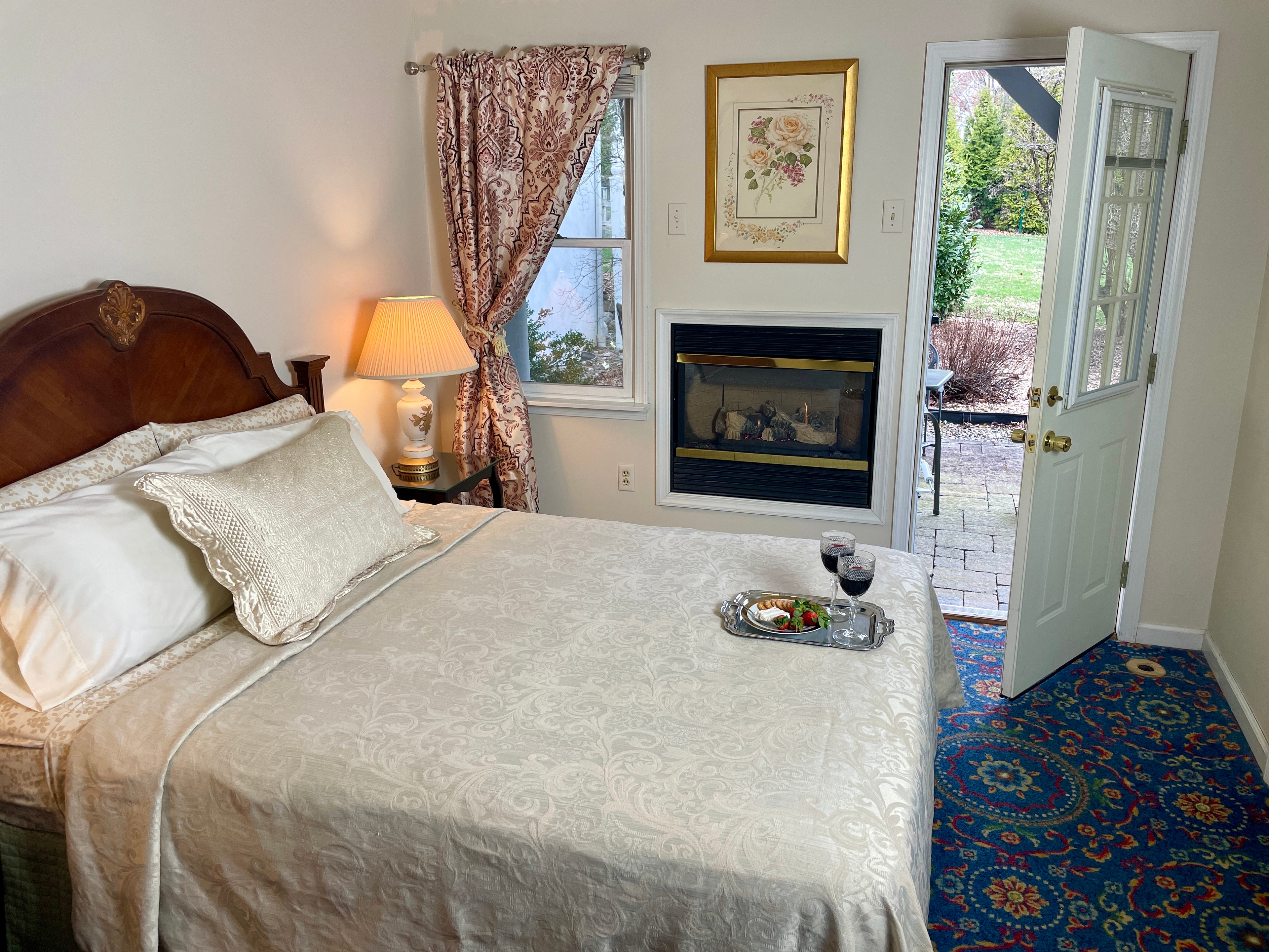 view of bed fireplace and outside patio entrance