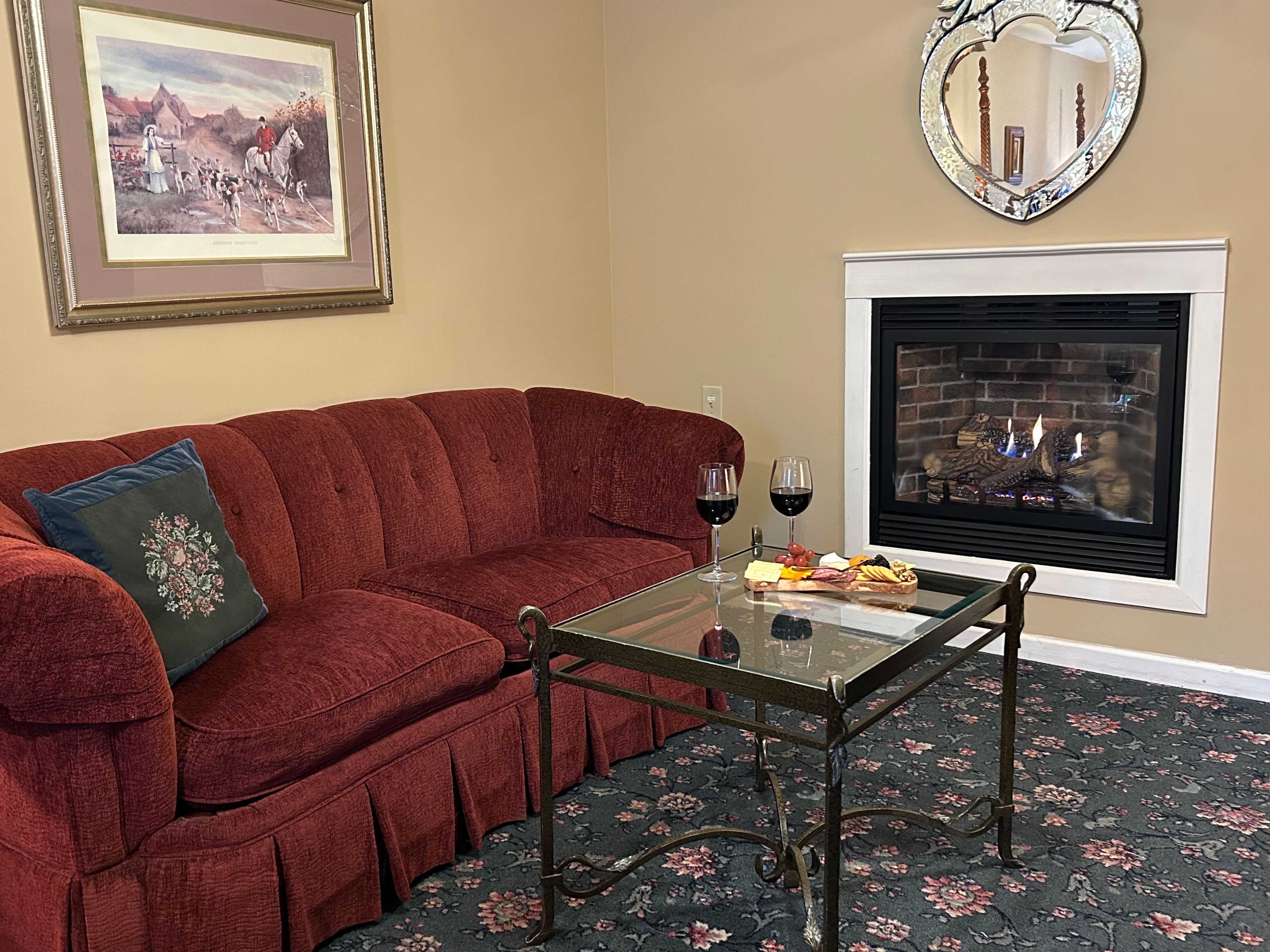 Sitting area with couch and table in front of the fireplace with wine and charcuterie