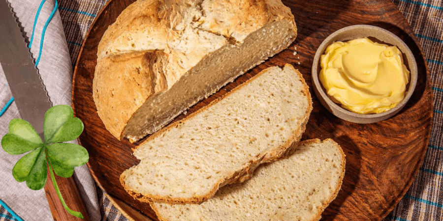 Sliced Irish soda bread on a wooden board with a small bowl of butter. Sliced Irish soda bread on a wooden board with a small bowl of butter.
