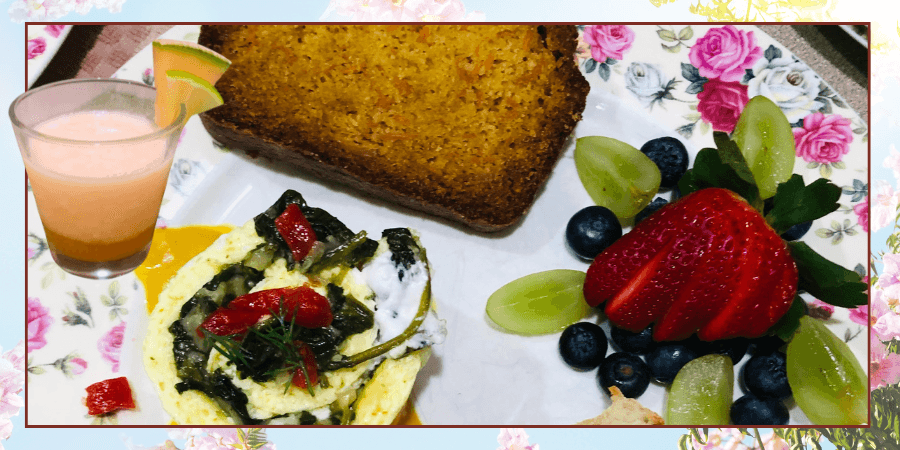 A colorful breakfast plate featuring a vegetable omelet, a slice of bread, fresh fruit, and a glass of pink beverage. A colorful breakfast plate featuring a vegetable omelet, a slice of bread, fresh fruit, and a glass of pink beverage.